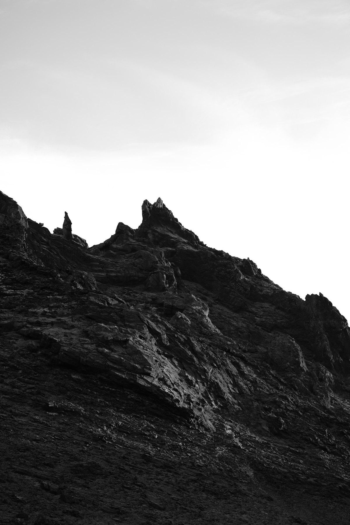 Black rock formation under a bright sky.